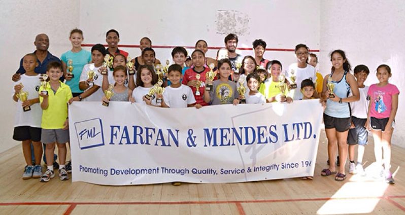 Prize winners of the Farfan and Mendes/Digicel Junior Christmas Squash Tournament strike a pose after receiving their trophies on Sunday at the Georgetown Club squash court.