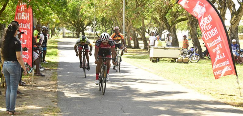 In this  Adrian Narine photo Geron Williams drives hard to the finish  line to win  the 35-lap Hand-in-Hand cycle race.
