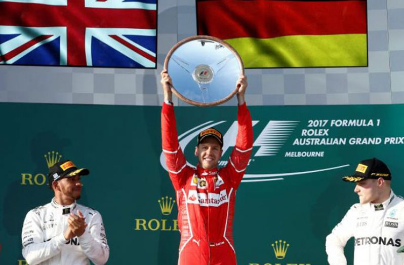Ferrari driver Sebastian Vettel of Germany (C) celebrates alongside Mercedes driver Lewis Hamilton of Britain (L) and team mate Valtteri Bottas of Finland. REUTERS/Brandon Malone