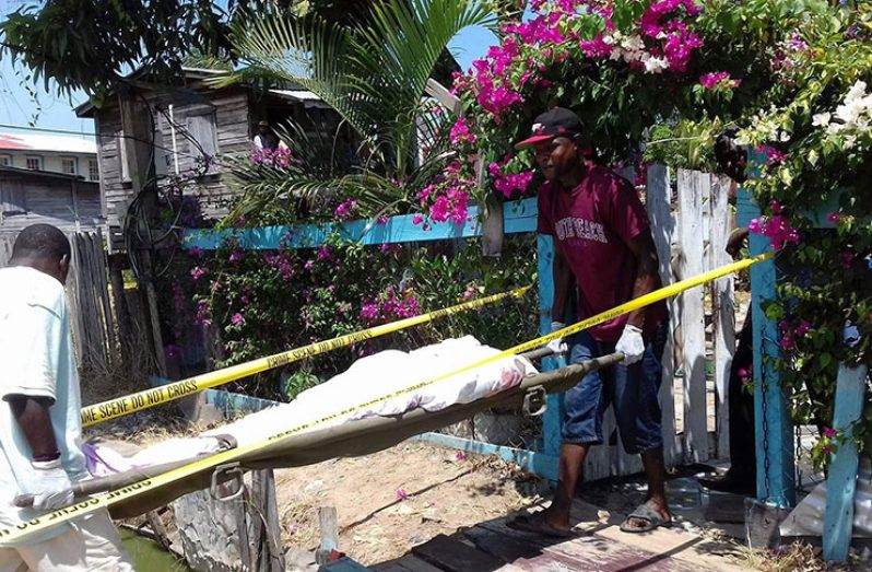 Undertakers removing the body of Bhulmattie Delall called "Mommy Gold", 53, from her home