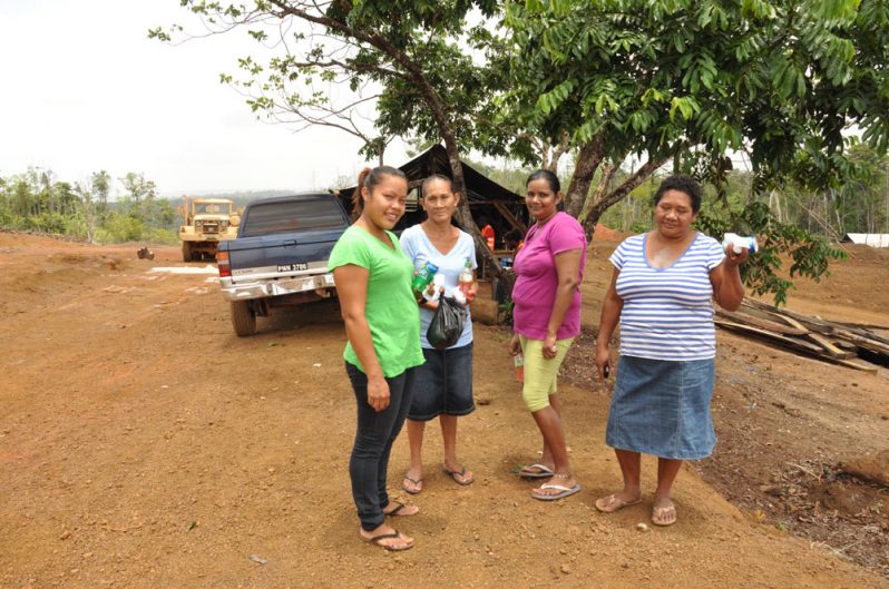 Jenifer Williams (second left) and Emily Williams (right), along with other 58 Miles residents pose for the Guyana Chronicle