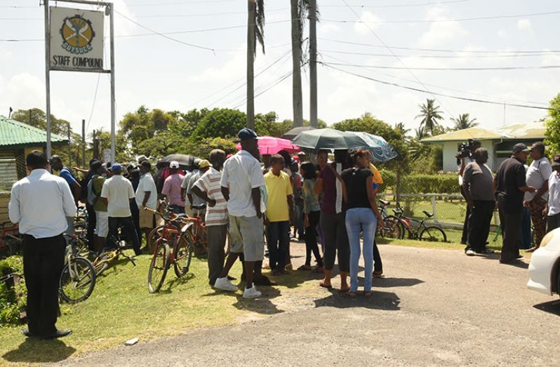 Ex-East Demerara Sugar Estates employees patiently await to collect their severance pay, at Enmore on Monday. (Photo by Adrian Narine)