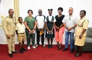 Commissioner of Police, Clifton Hicken, with the children who received sponsorship, parents and Mohamed Qualander, CEO of Queensway Security Services Inc. (second from right) in Eve Leary