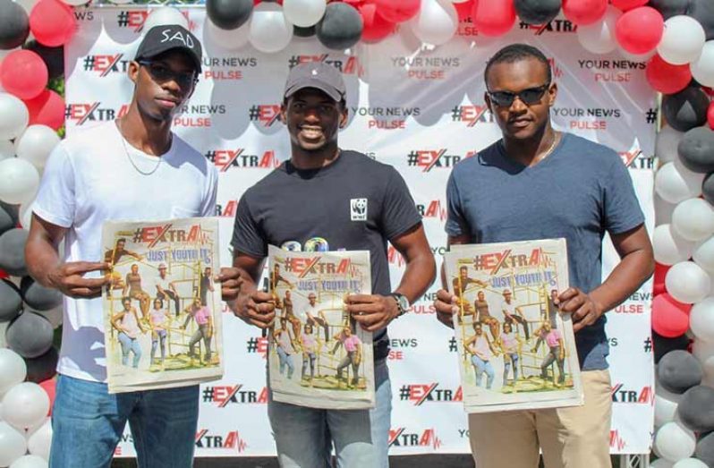 These young men pose with # Extra, the youth newspaper that was launched on Saturday (Vishani Ragobeer photo)