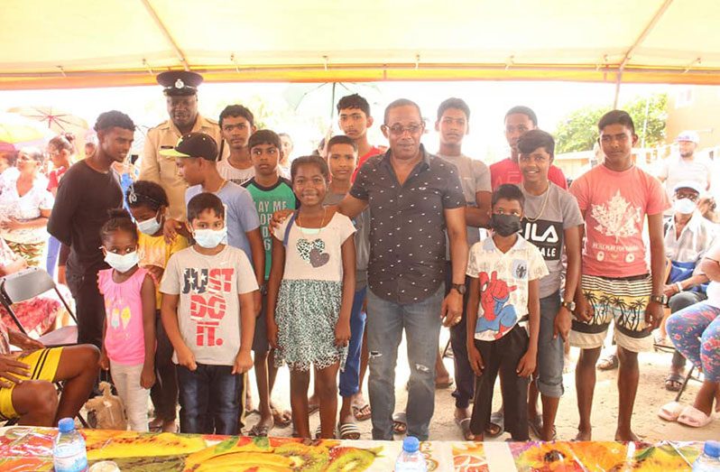 Commissioner of Police (ag) Clifton Hicken with a group of children and youths from the community. He referred to them as the "catalyst for change" (Guyana Police Force/ Troy Vanrossum photo)