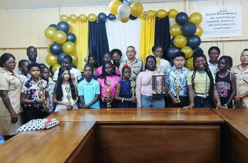 Commander Khali Pareshram (centre) flanked by Police Youth and Scout Group members, along with children of police officers, who recently wrote the NGSA and his Administrative Team